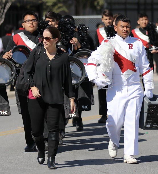Roma High School band director Dena Laurel walks with the drum major and other band members.