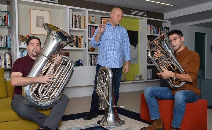 Aaron Tindall working with two students, one playing the tuba, the other playing the euphonium