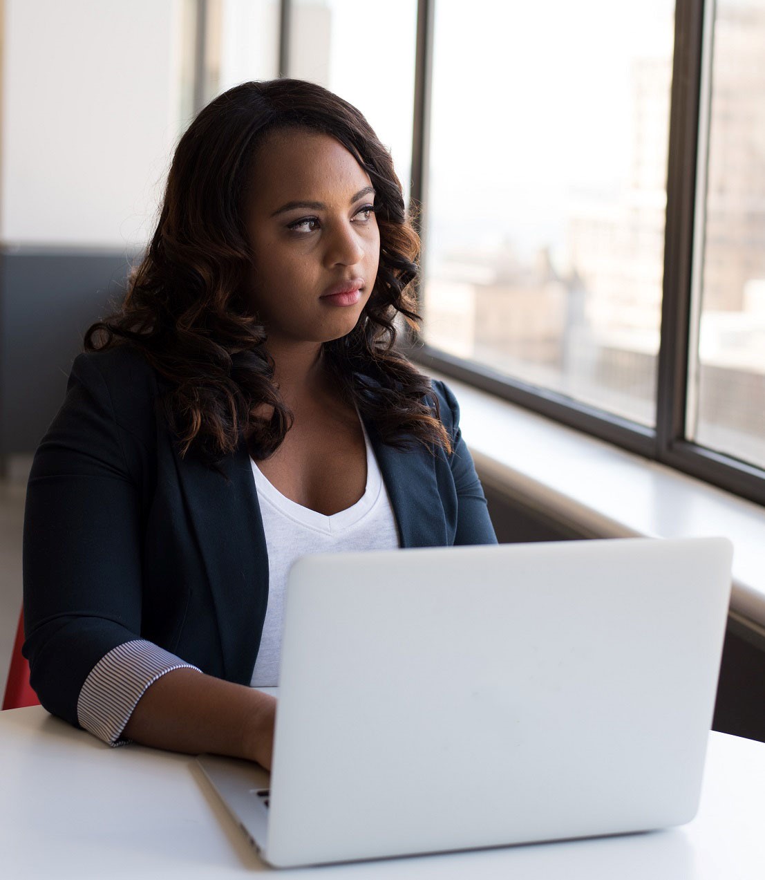 female working on laptop while looking out window