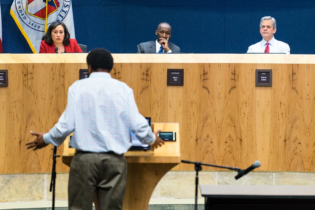 Male talking in front of school board