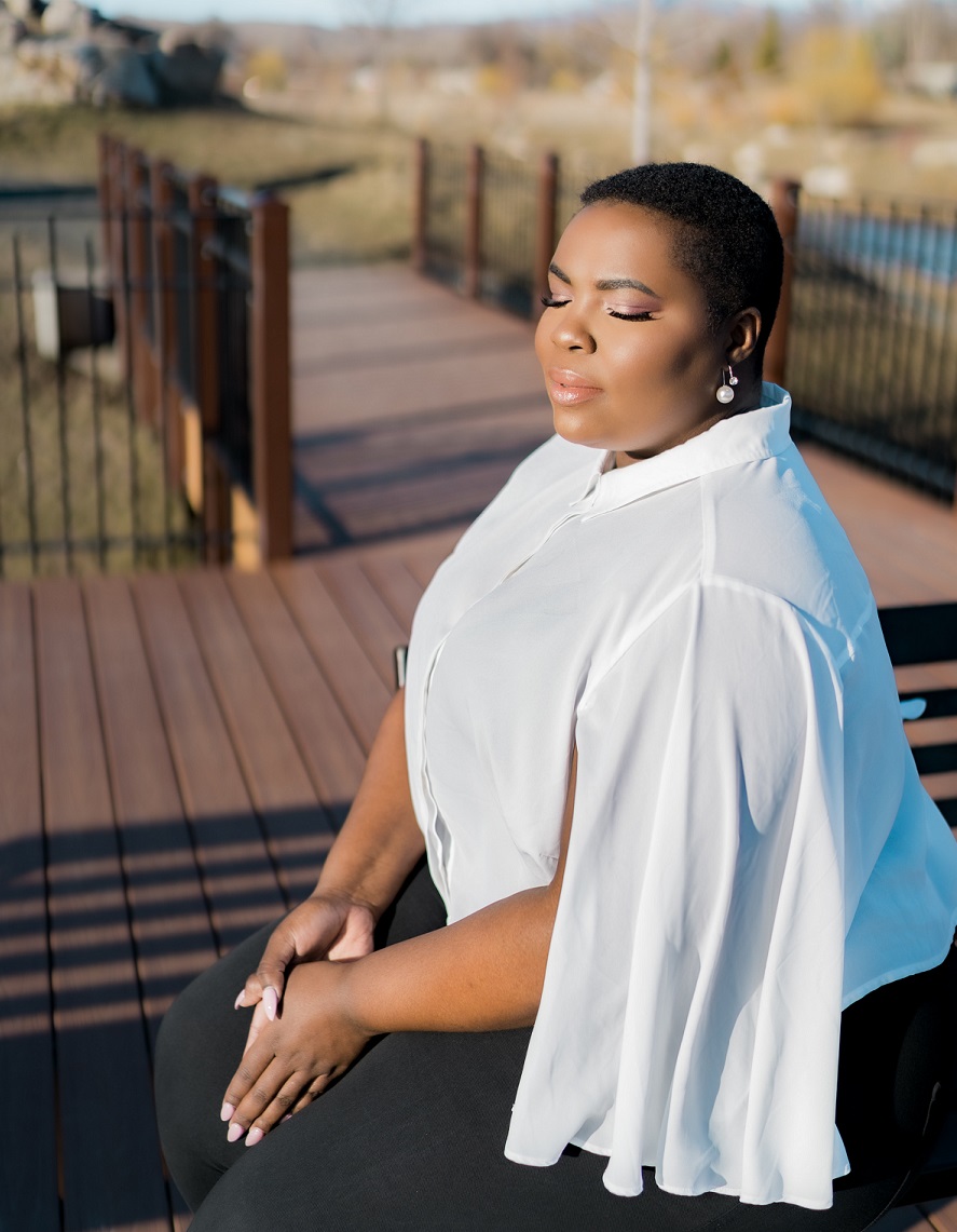 peaceful-looking woman sitting outdoors with eyes closed 