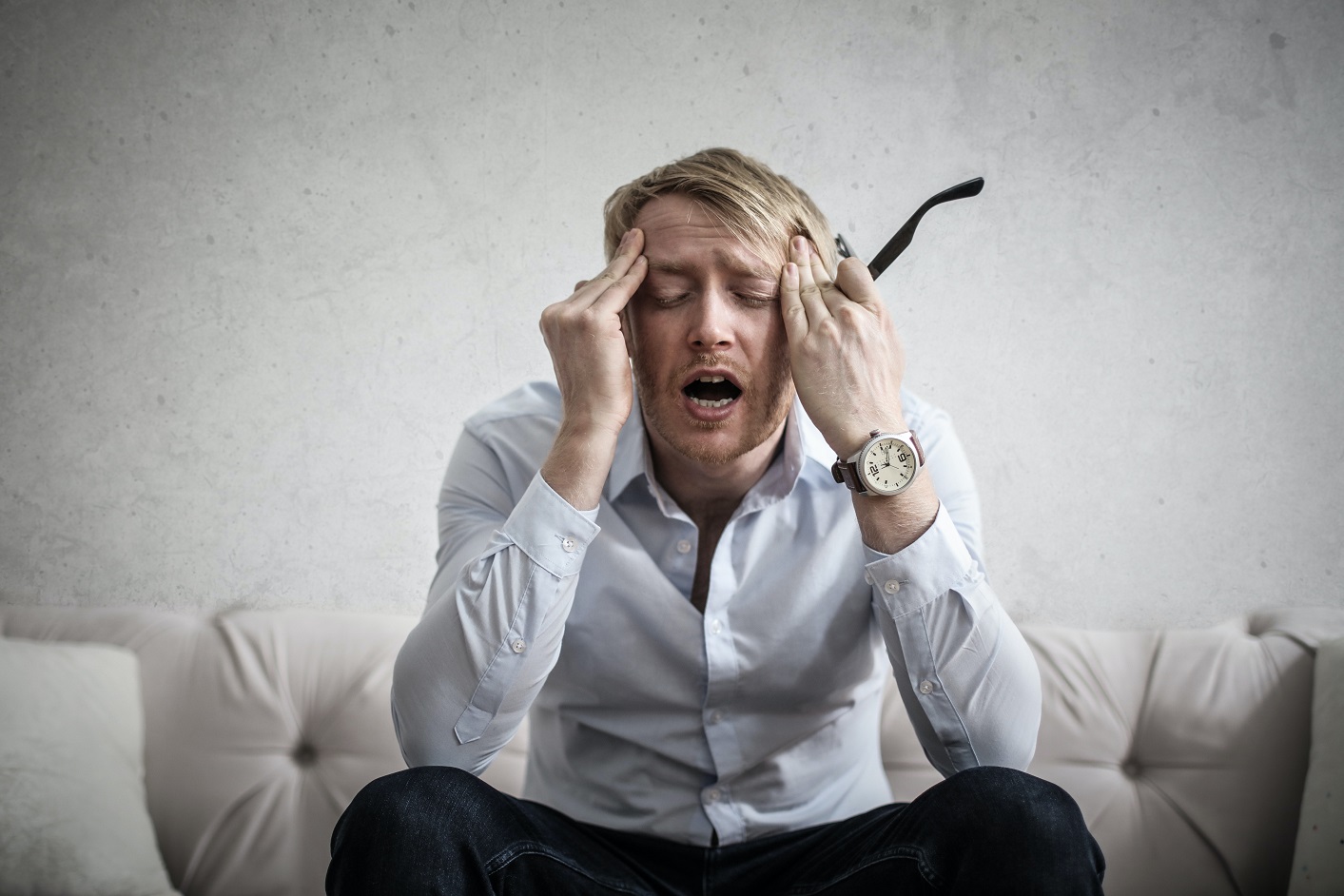 stressed out man putting fingers on the sides of his head 