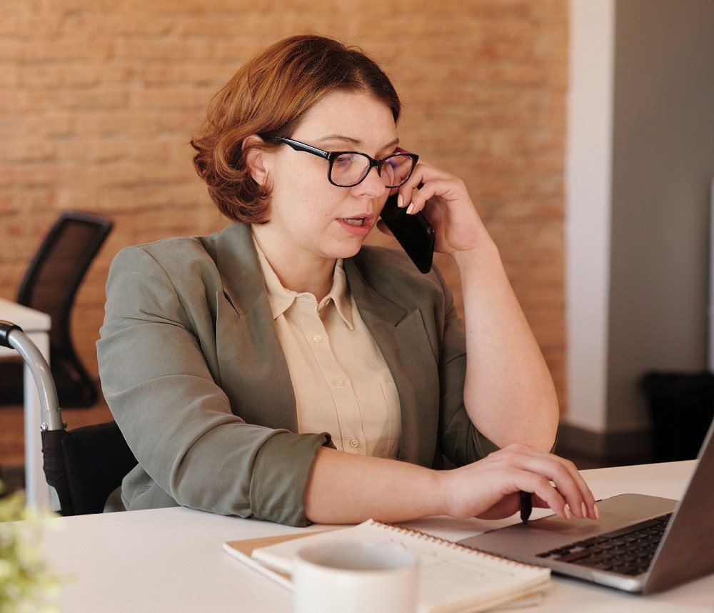 woman on laptop and talking on cell phone