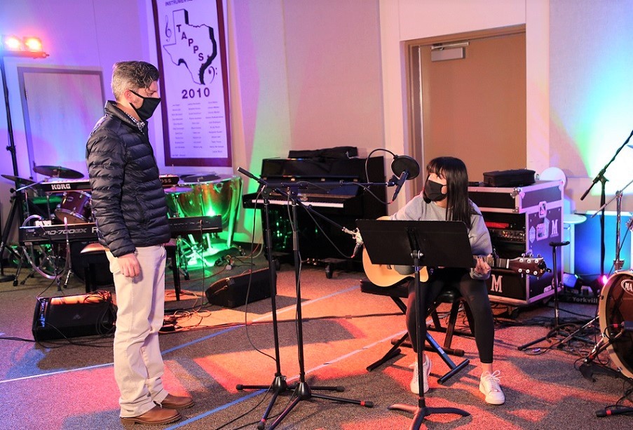 Steve Moreland wearing mask with student in music room 