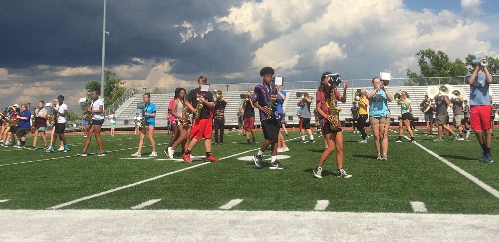 Topeka High School marching band practicing on field 