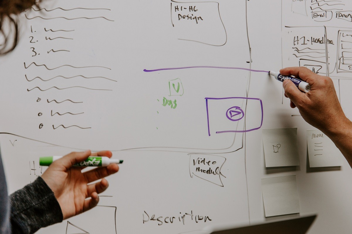 man and woman working on whiteboard 