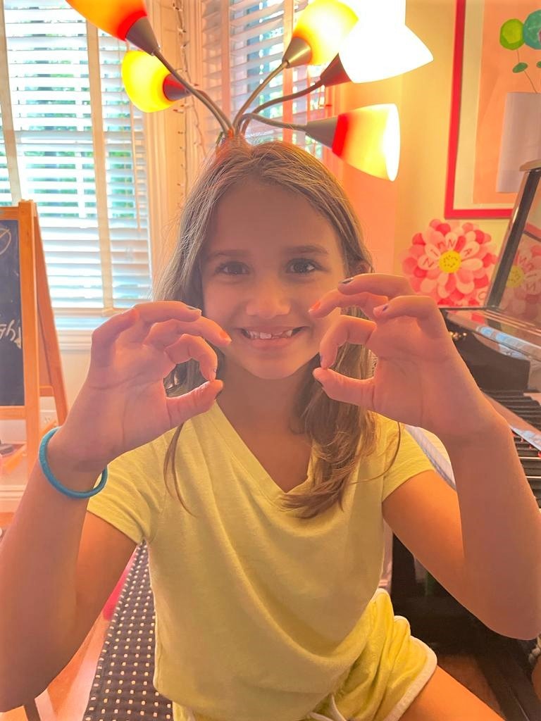 student making Os with her thumb and index fingers