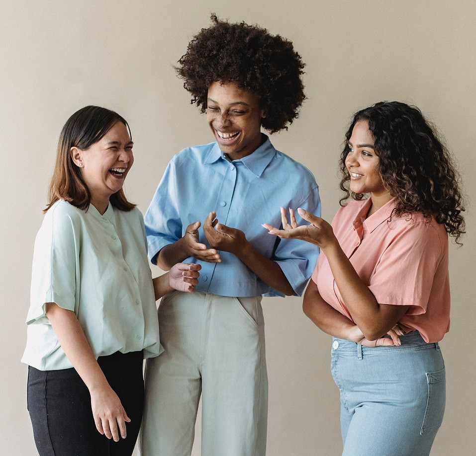 three smiling women talking 