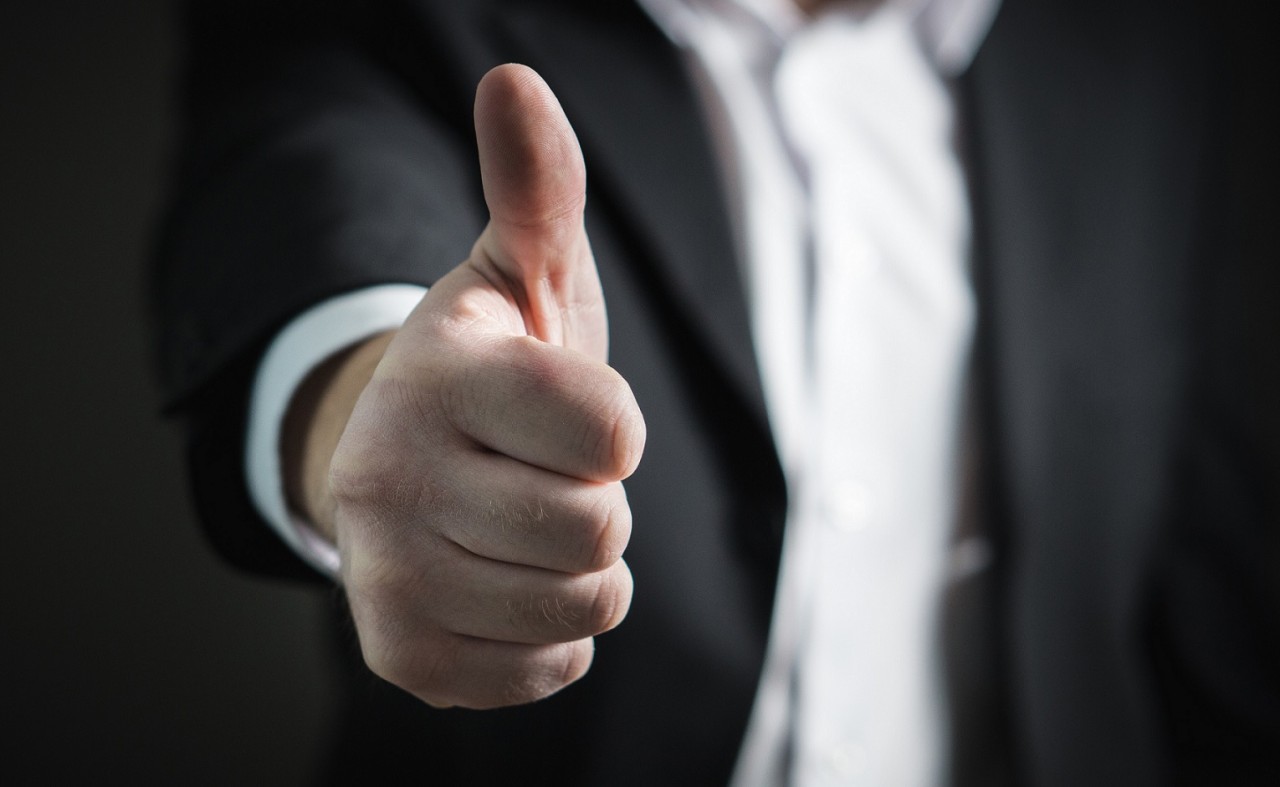 closeup of man's thumbs up hand 