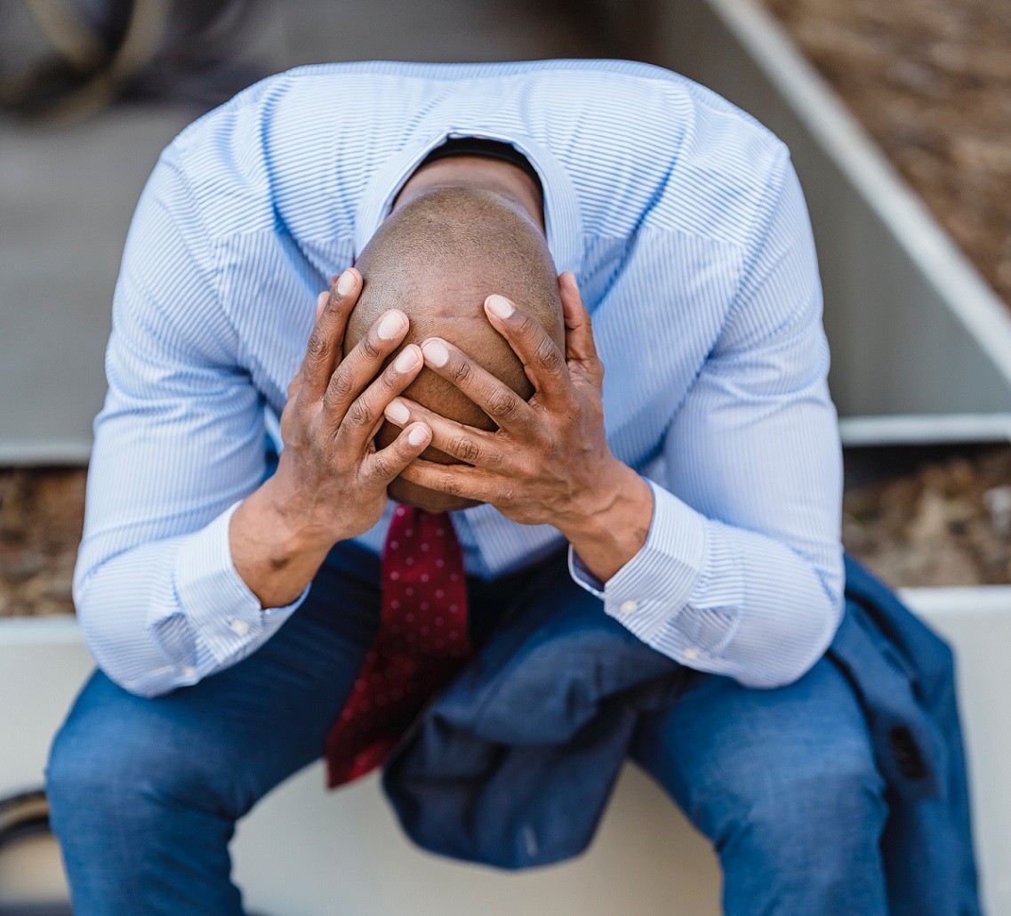 man sitting with head in his hands