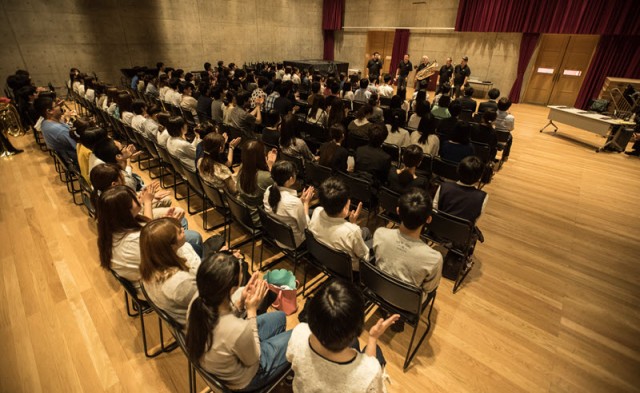 members of the Boston Brass speaking in front of a room full of music students at a clinic