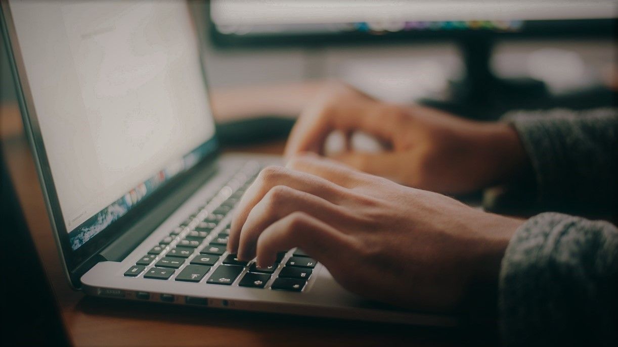closeup of someone typing on laptop