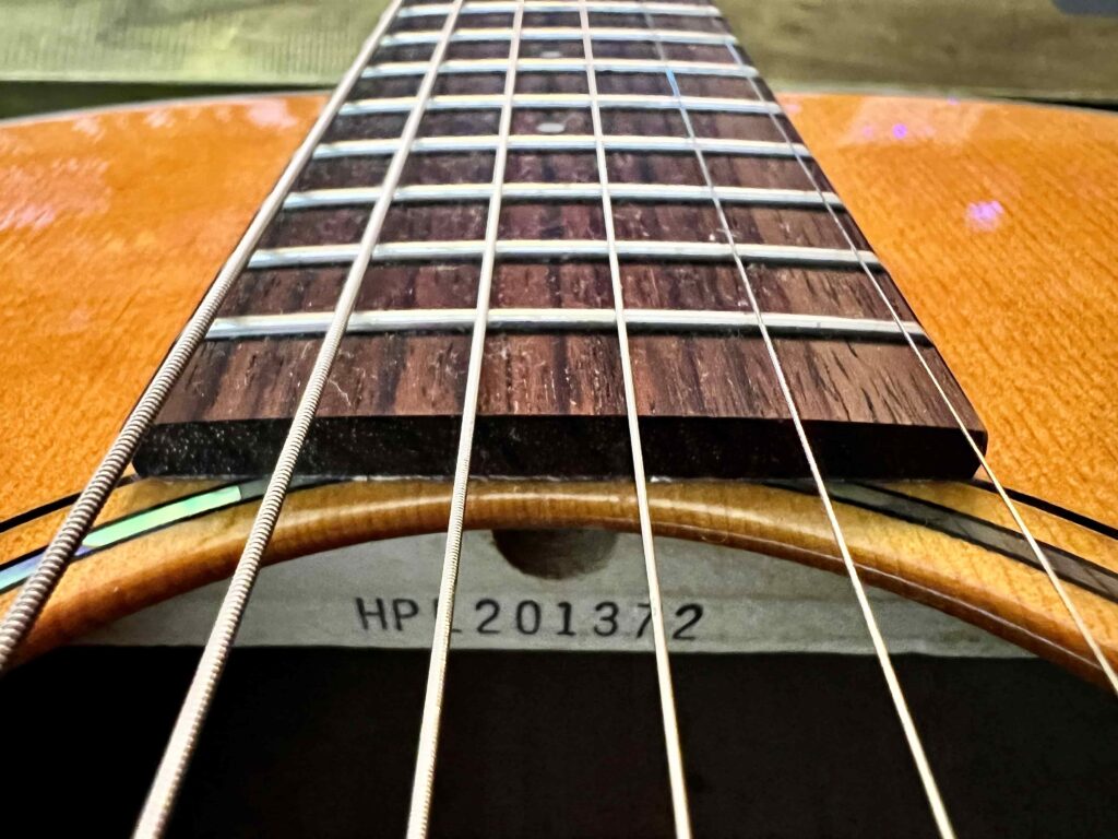 Acoustic guitar sound hole looking up towards the neck.