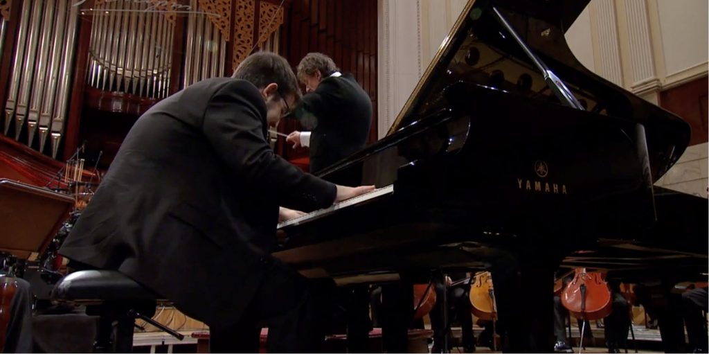 2015-Chopin-Competition-crop-v2 Man intensely playing a Yamaha concert grand on stage.