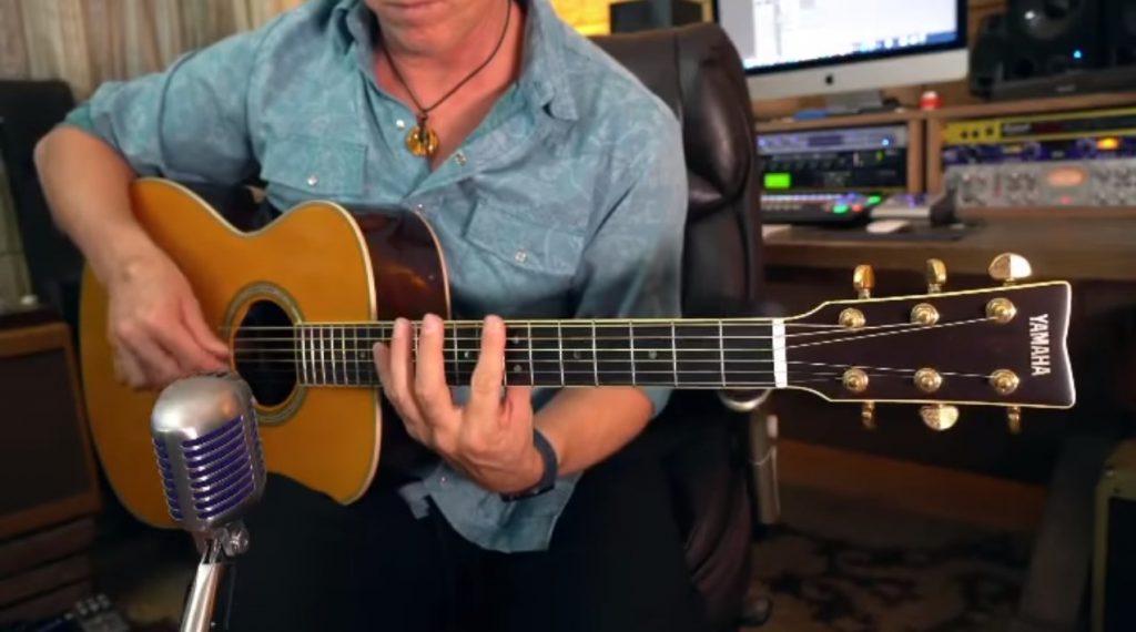 Guitarist playing acoustic guitar.