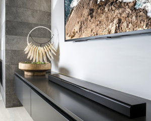 Sound bar on a cabinet below a flat screen tv.