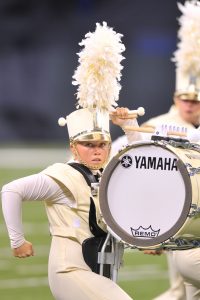 Marching drummer hitting a bass drum.