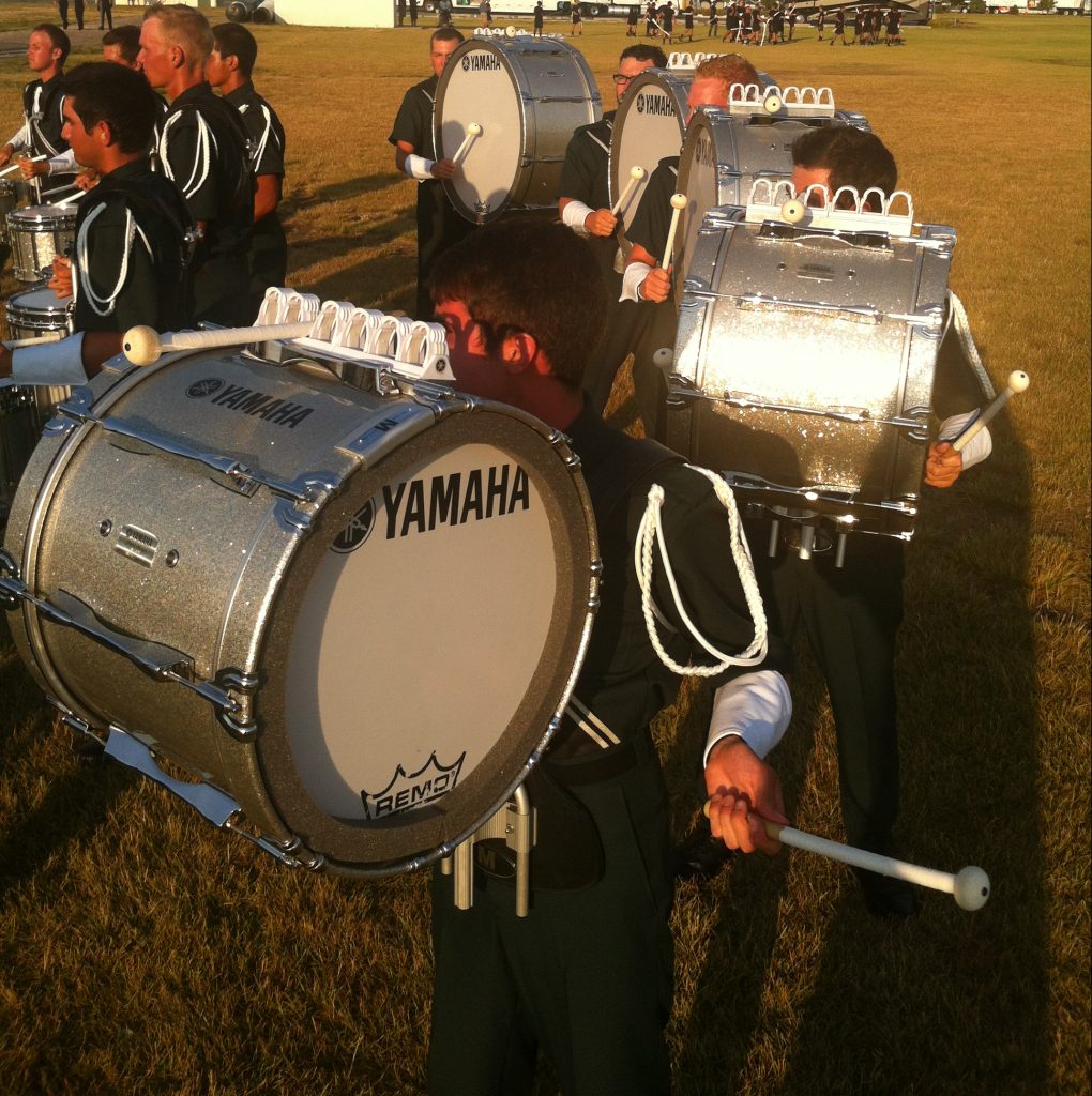 Impact Strips Body Image 2 A group of drummers practice in an open field.