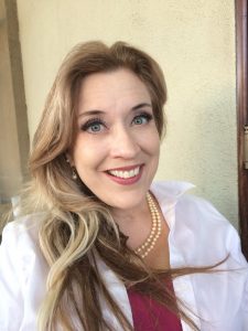 A woman with long sandy color hair smiling for camera.