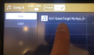 Genos and Chord Tracker Body Image 16 An image of a Genos digital display with a specific song file highlighted.