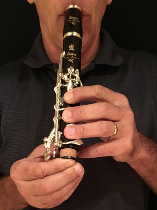 clarinet wont play image 1 Close-up of man blowing through a disassembled clarinet.