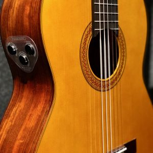 calvo may fig 3 Closeup of the body of an acoustic guitar with three knobs on side for reverb, volume and chorus.