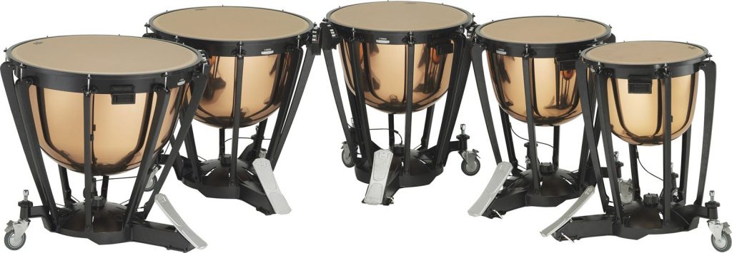 Set of 5 timpani drums in a curved row.