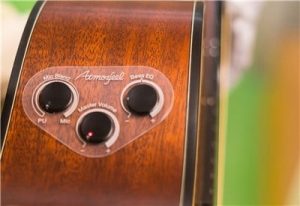 Closeup of dials on side of acoustic guitar body.