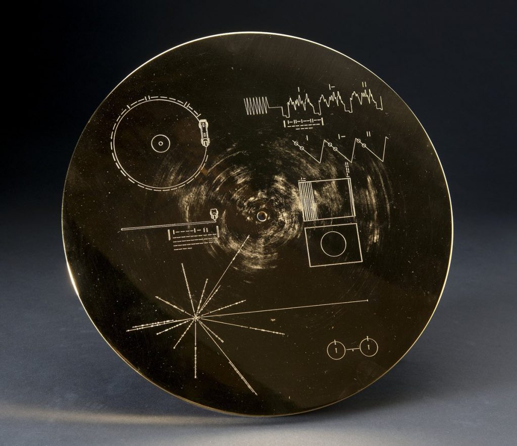 voyager record air and space A cicular case with diagrams drawn on it.