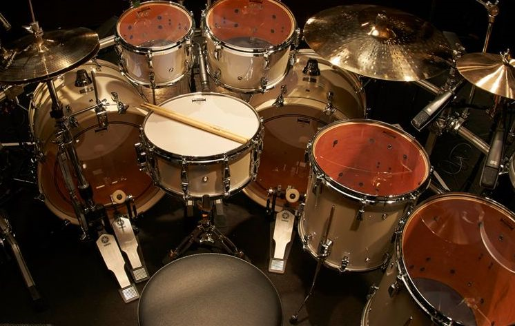 collection of snare drums Drum set with multiple drums, cymbals, pedals and sticks.