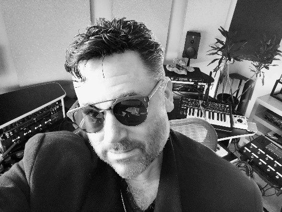 rich tozzoli Man in sun glasses sitting at mixing console.