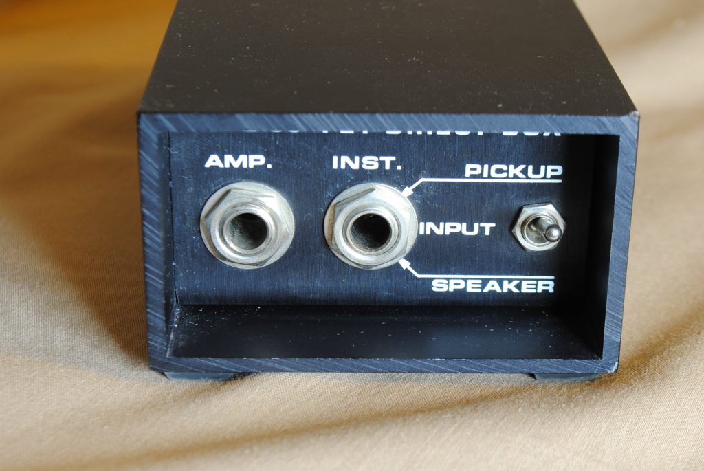 tott di fig21400 Closeup image of a direct input or "DI". There are two female inputs and a toggle switch.