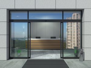 Sliding doors in a high rise office building that are open and the reception desk is beyond.