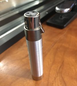 Closeup of inline pad - a small cylinder with closed end with three perforations.