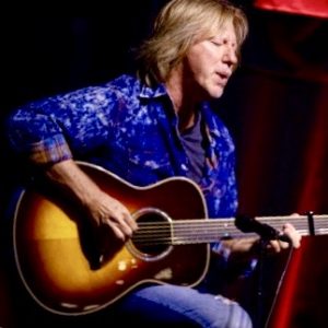 Robbie Calvo playing an acoustic guitar.