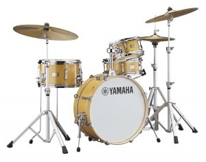 A small portable drum set in natural wood grain.