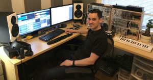 A man sitting in a sound design studio.