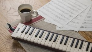 Yamaha Pianica keyboard wind instrument on table with coffee cup.
