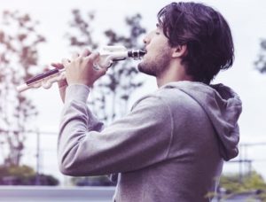 Young man playing a Yamaha Venova casual wind instrument.