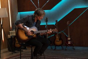 View of Keith Urban playing an acoustic guitar.