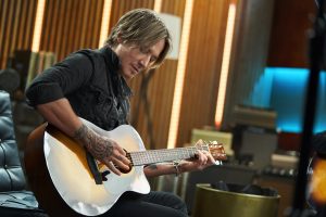 Keith Urban playing an acoustic guitar.