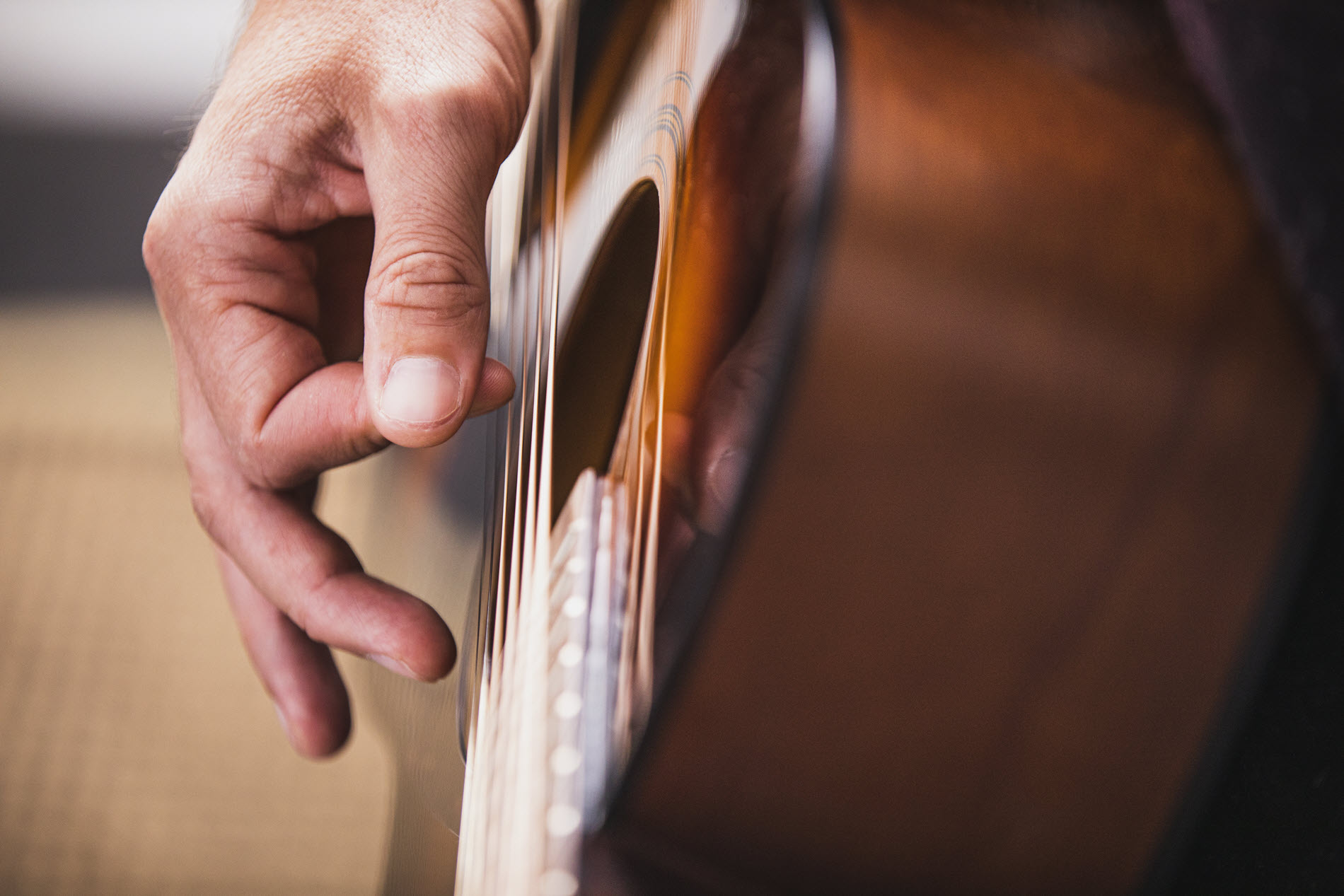 guitartips6 Closeup of someone playing an acoustic guitar.