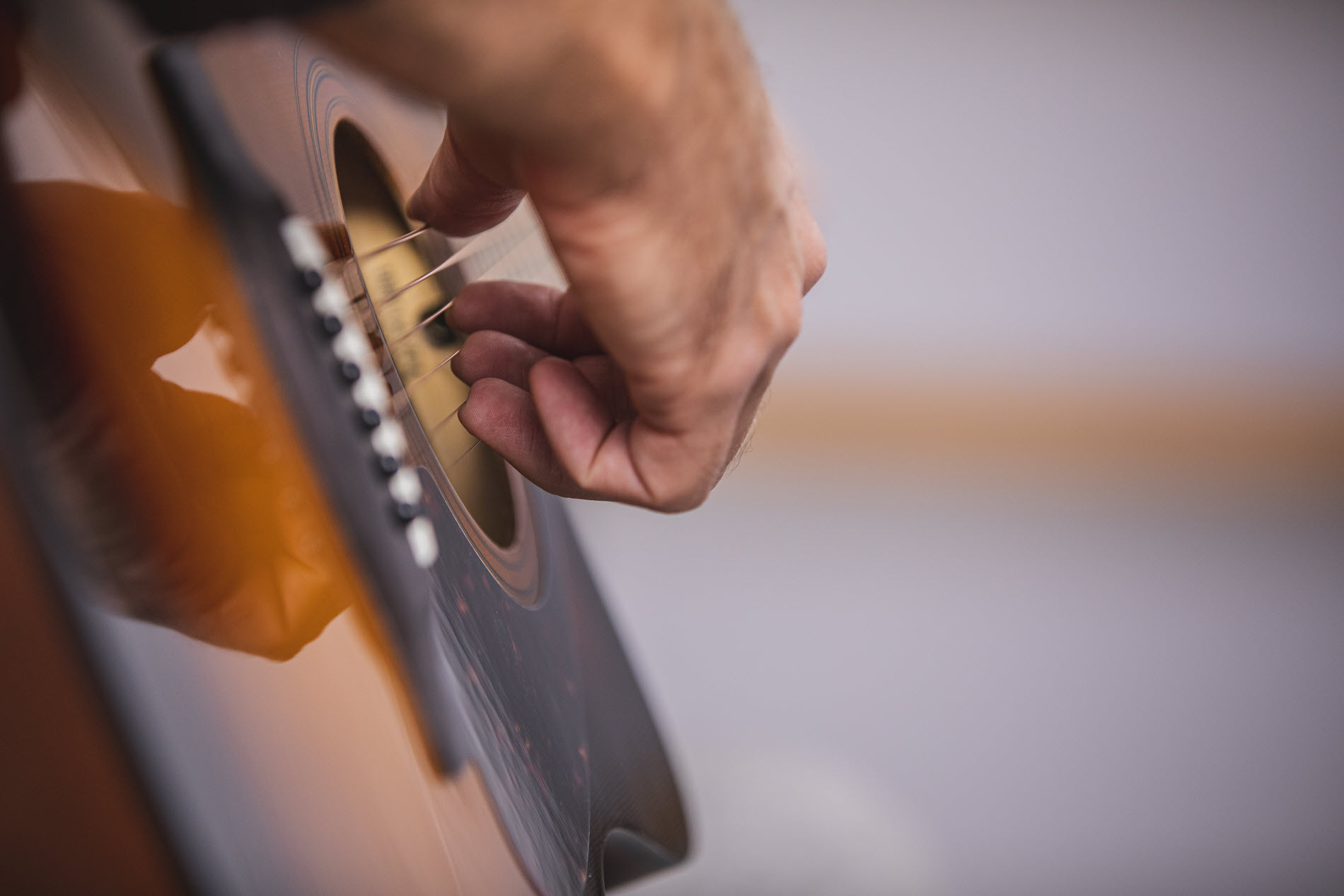guitartips7 Closeup of someone's hands as they play acoustic guitar.
