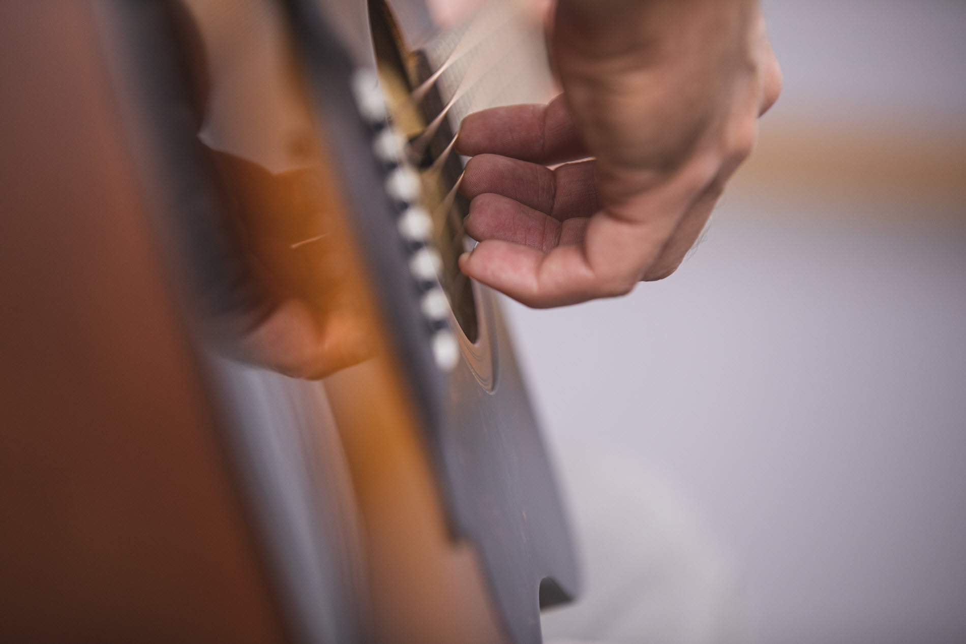 guitartips8 Closeup of someone's hands playing acoustic guitar.