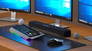 Yamaha sound bar on desk beneath computer monitors.