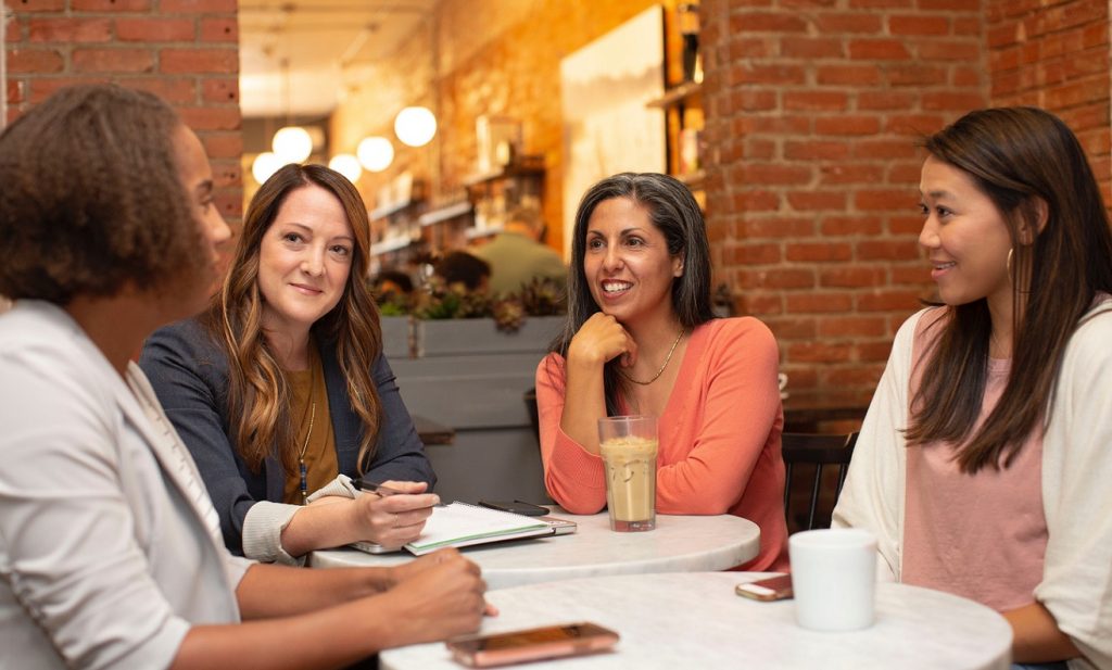 four female friends sitting around a table