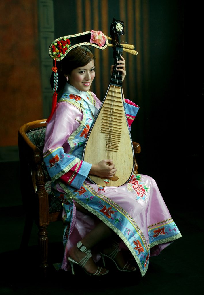 pipa Woman in traditional dress holding a wooden stringed instrument.