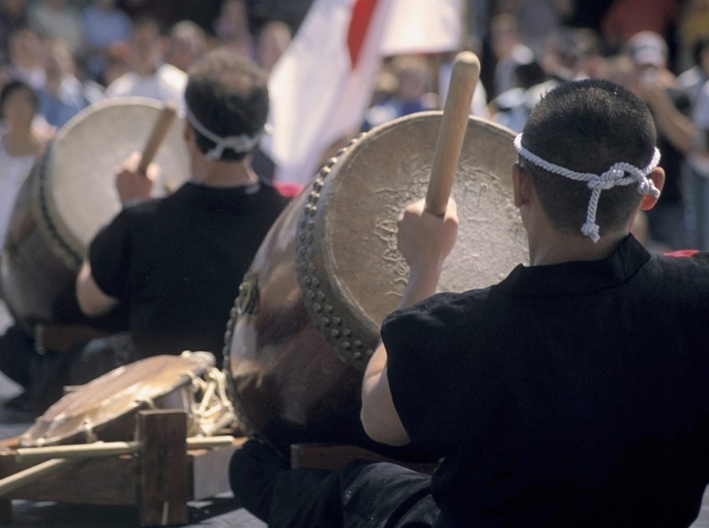 Taiko-Drums Group of men performing on large traditional drums.