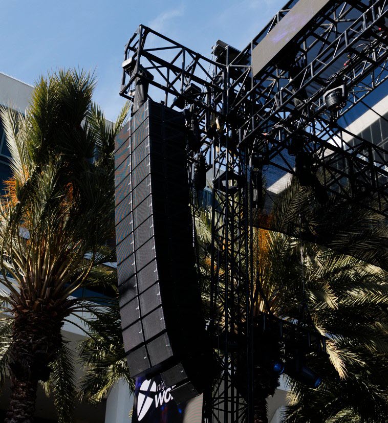 NEXO-array-2-cropped Tall stack of speakers supported by scaffolding.