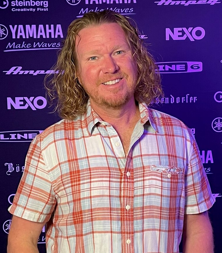 A young man in a short-sleeve plaid shirt.